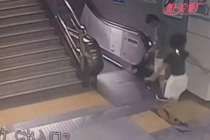 女子走到地铁站电梯前盖板处