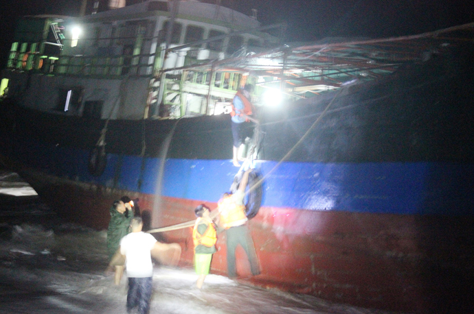 武警台风巨浪中帮助渔民下船