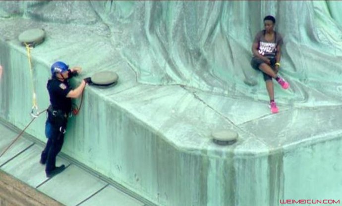 女子在自由女神像上与警察交谈