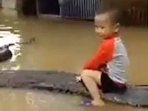 男童身骑80公斤巨蟒 洪水里与蛇共舞面不改